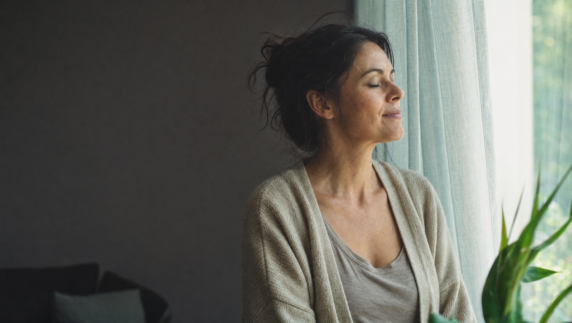 Femme à sa fenêtre, respiration calme.